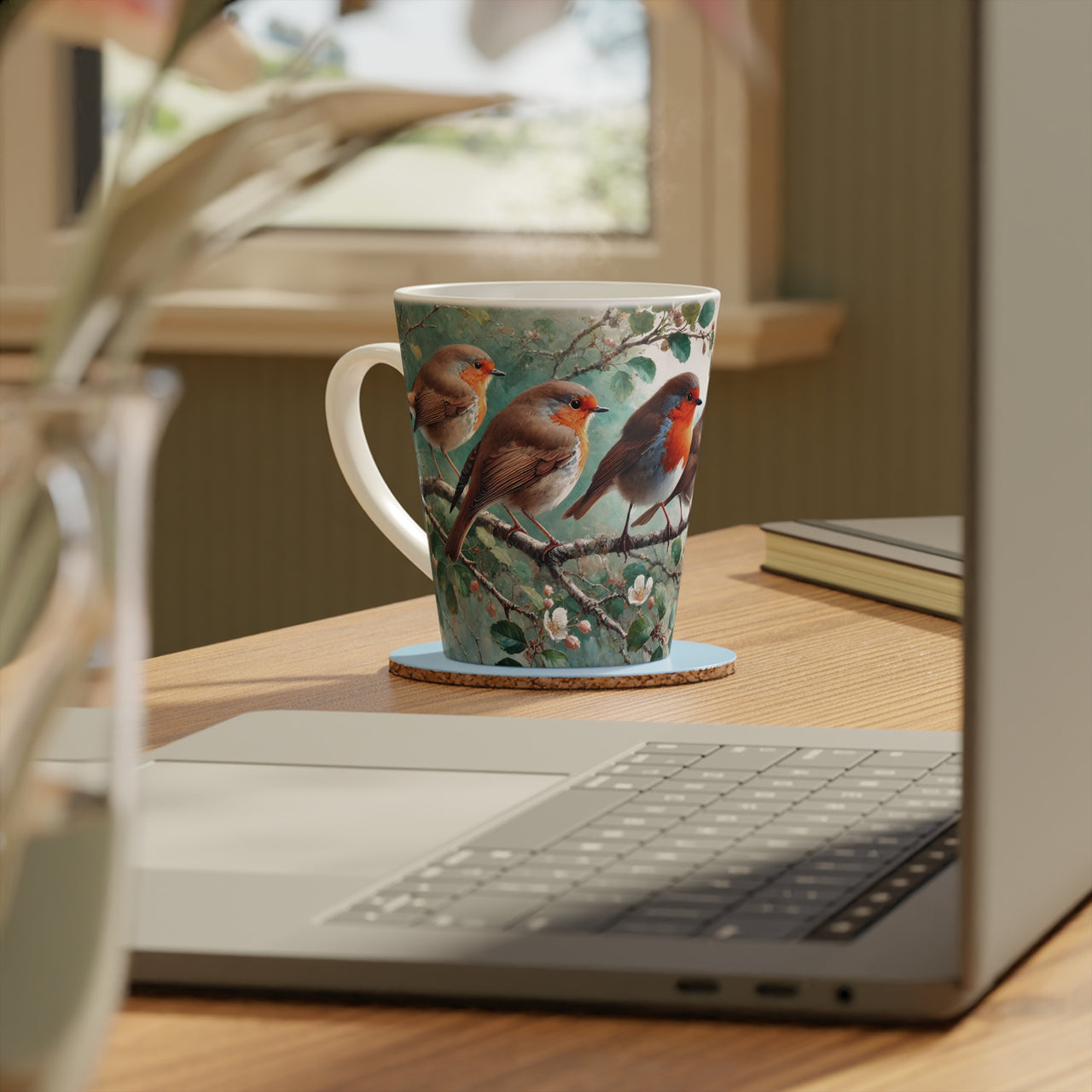 Ceramic mug featuring an illustration of three red robin birds perched on a branch surrounded by foliage, designed for bird lovers and nature enthusiasts, with a detailed, nature-inspired artwork.